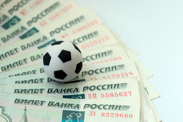 The concept of corruption, bribes or sports betting. A soccer ball on Russian banknotes with a face value of one thousand rubles.