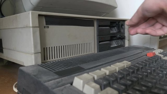 Inserting the 5.25 Inch floppy disk in outdated computer. Old pc 1980s - 1990s

