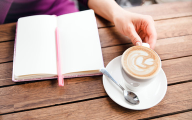 Hands writting at notebook in cafe