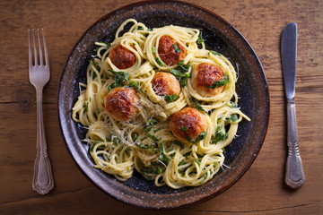 Pasta with meatballs and spinach. Spaghetti with meatballs in bowl on wooden table. overhead, horizontal