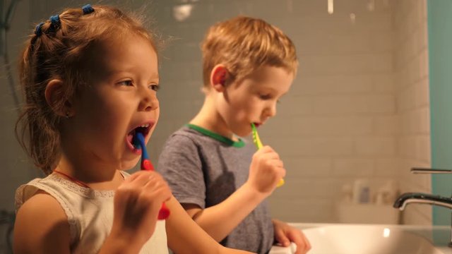 Hygiene of children brother and sister enjoy brushing their teeth in a bathroom at home