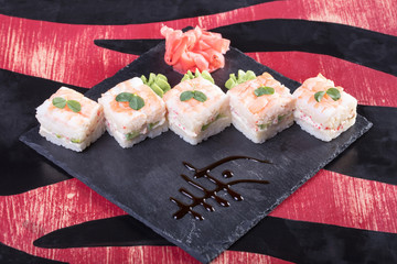 Японская кухня. Горячие и холодные закуски из морепродуктов. Суши и роллы и креветки. Японская еда и морепродукты в ресторане.