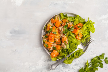 Healthy quinoa salad with roasted pumpkin and greens, top view, copy space. Healthy vegan food concept.