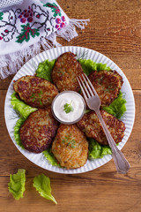 Potato pancakes with sour cream or yogurt. Vegetable fritters, latkes, draniki. View from above, top studio shot