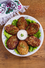Potato pancakes with sour cream or yogurt. Vegetable fritters, latkes, draniki. View from above, top studio shot