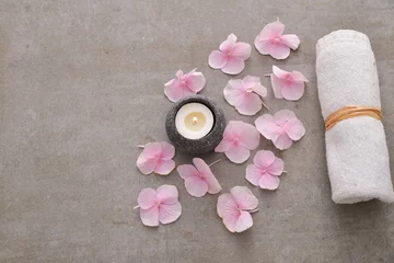  Many Pink hydrangea petals with candle in stone bowl ,towel on gray background © Mee Ting