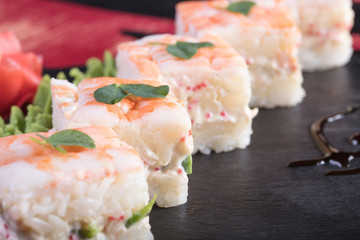Японская кухня. Горячие и холодные закуски из морепродуктов. Суши и роллы и креветки. Японская еда и морепродукты в ресторане.
