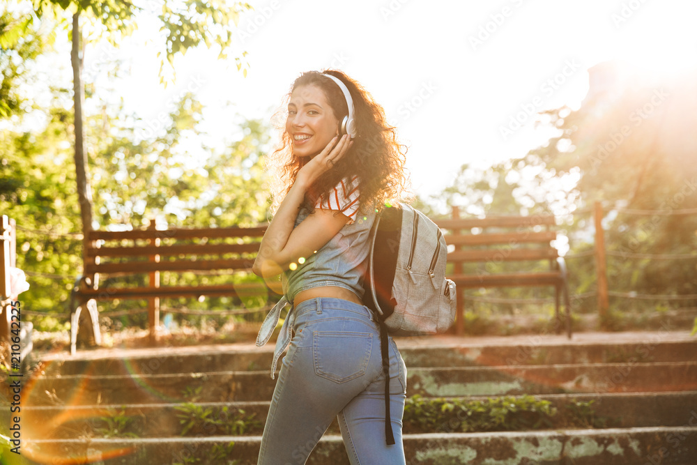 Wall mural Cute young woman walking by steps