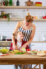 Picture of young mother with her daughter cooking food in kitchen