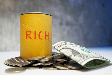 US dollars and coins fill a glass tip jar with money