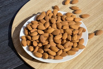 Almonds in plate. Plate full of almonds kept outside in sun.