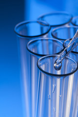 glass test tube with dropper on blue background with substance