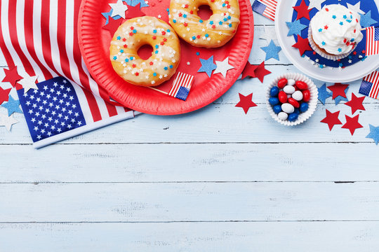 Independence Day Background On 4th Of July With American Flag, Stars And Food On Wooden Table Top View.