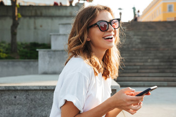Picture of european brunette woman wearing casual summer outfit and sunglasses, laughing while...