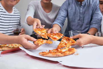 Positive joyful friends enjoying their pizza