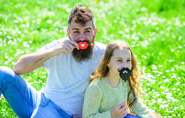 Gender roles concept. Family spend leisure outdoors. Dad and daughter sits on grassplot, grass on...