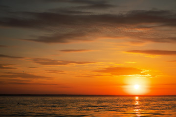 Naklejka na ściany i meble Beautiful fiery sunset sky on the beach. Composition of nature