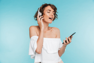 Portrait of a delighted young woman listening to music