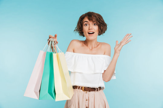 Portrait of an excited young woman showing shopping bags