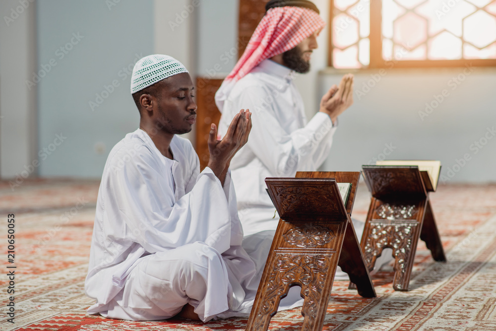 Poster two religious muslim man praying together inside the mosque