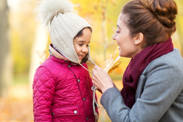Fototapeta premium family, season and people concept - happy mother and little daughter at autumn park