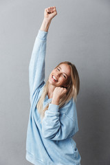 Portrait of an excited young blonde girl celebrating