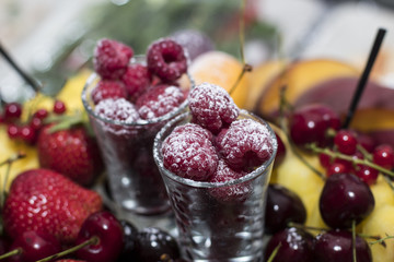 Raspberry in a glass of wine sprinkled with powdered sugar