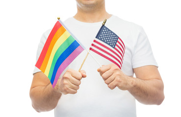 lgbt, same-sex relationships and homosexual concept - close up of man holding gay pride rainbow and american flag