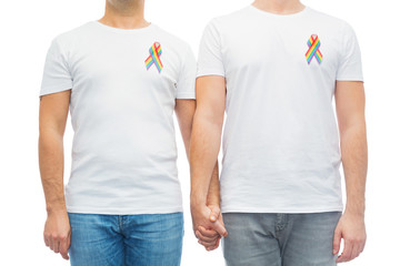 lgbt, same-sex relationships and homosexual concept - close up of male couple with gay pride rainbow awareness ribbons