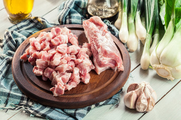 Raw pork belly pieces on a cutting board