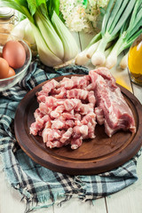 Raw pork belly pieces on a cutting board