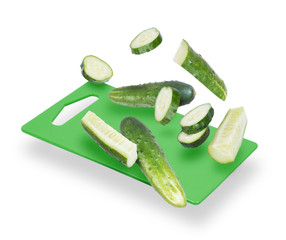 Slices of cucumber fall on the kitchen board