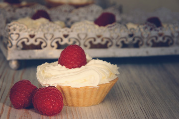 Cake in tartlet made from white cream, decorated with ripe raspberries