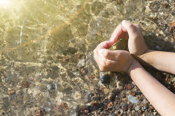 heart of the hands on the background of the sea shore.