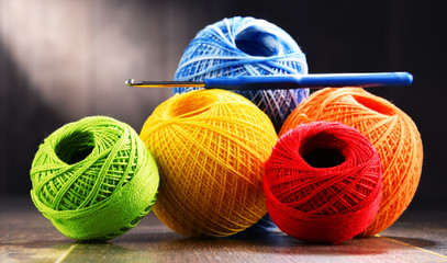 Colorful yarn for crocheting and hook on wooden table