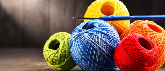 Colorful yarn for crocheting and hook on wooden table - obrazy, fototapety, plakaty