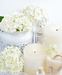 Fototapeta na wymiar Spa composition with candles, cream, salt and flowers of hydrangea on a white background