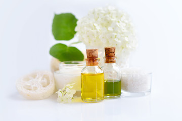 Obraz na płótnie Canvas Spa composition with aroma oils, cream and flowers of hydrangea on white background