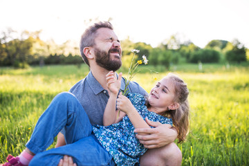 Father with a small daughter having fun in spring nature.
