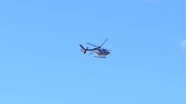 Police helicopter keep order fly over public center streets during carnival days in Tenerife