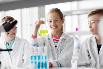 education, science and children concept - kids with test tubes studying chemistry at school laboratory - Powered by Adobe