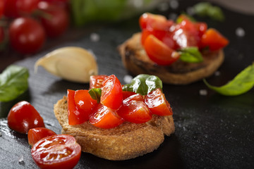 Italian antipasto called Bruschetta topped with tomatoes, garlic and basil