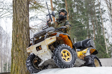 Cool quad bike rider with paintball marker