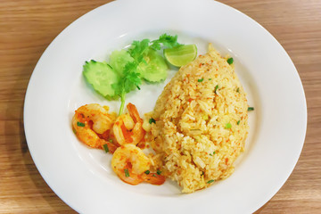Fried Rice with Shrimp Paste in white dish on the wooden floor.