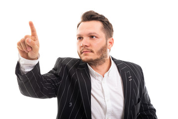 Portrait of young business man pointing invisible touchscreen.