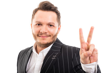 Portrait of young business man showing victory sign.