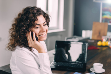Jewish business woman speaks by phone in the office.
