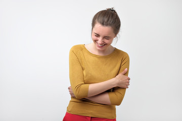 Young European girl in a yellow sweater giggling