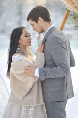 Winter wedding European bridegroom and Asian bride