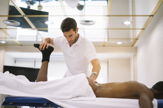 The physiotherapist treating a man using equipment for radio therapy